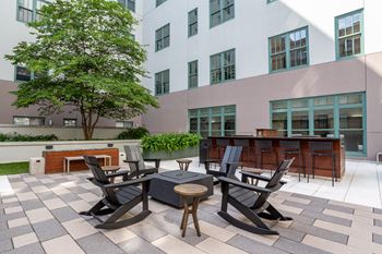 an outdoor patio with tables and chairs and a building in the background  at The Cosmopolitan, Minnesota, 55101
